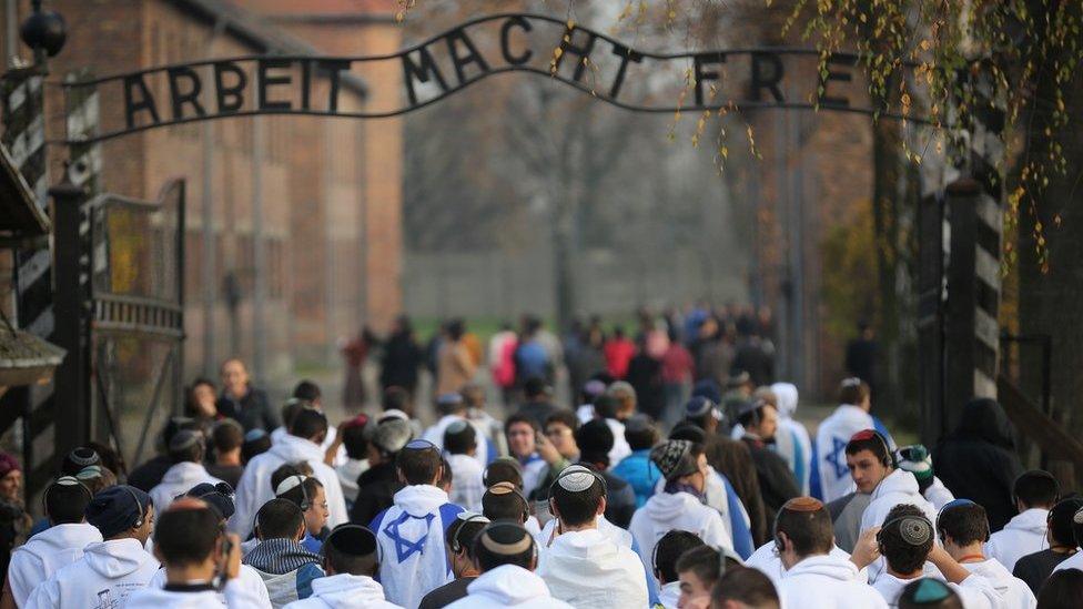 Young Israelis walk under the infamous German inscription that reads 'Work Makes Free' at the main gate of the Auschwitz I extermination camp in November 2014