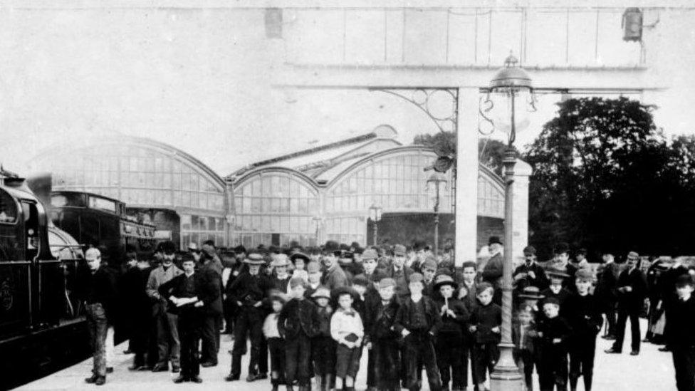 Crowds gather around an old steam train at Alnwick station