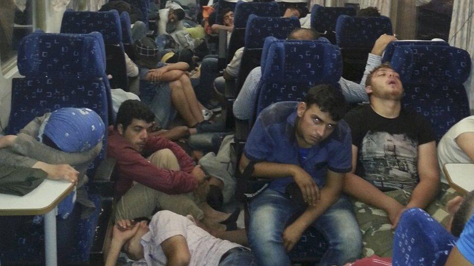 Refugees sleep on a train at Bicske railway station, Hungary