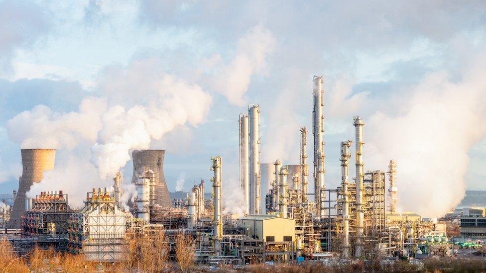 Steam and smoke rising from distillation towers and cooling towers towards the left at Grangemouth oil refinery and petrochemical plant in Central Scotland.