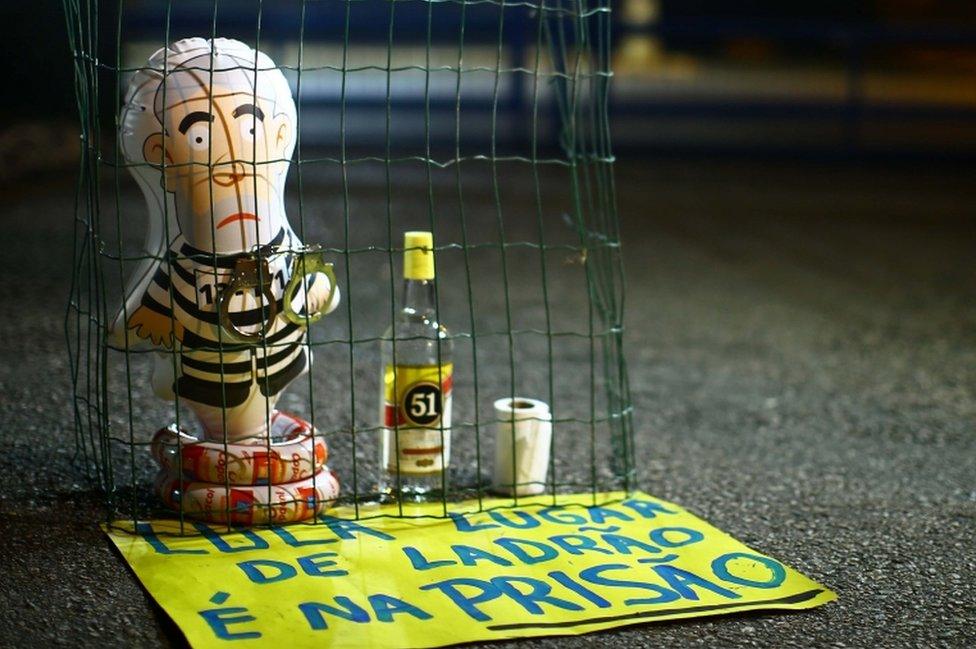 Pictured: A balloon depicting Lula as an immate, and a sign reading "Lula, the place for a thief is prison."