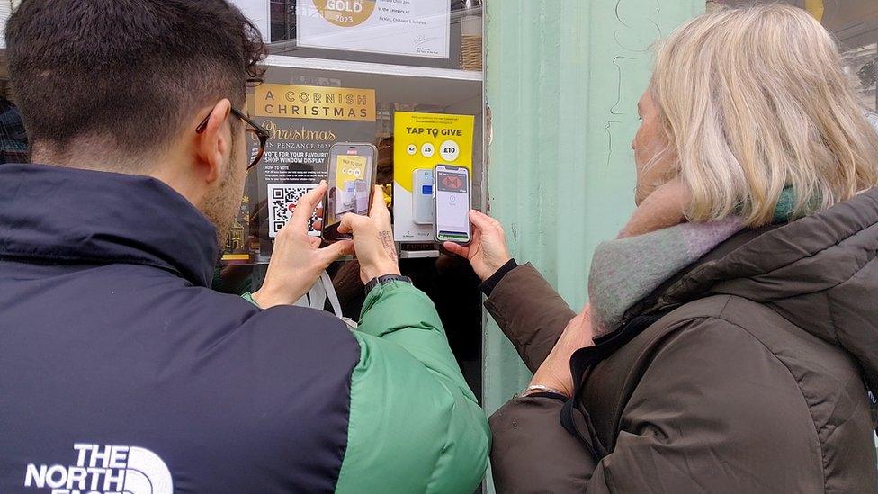 Members of the public donating money through the contactless donation points in Penzance