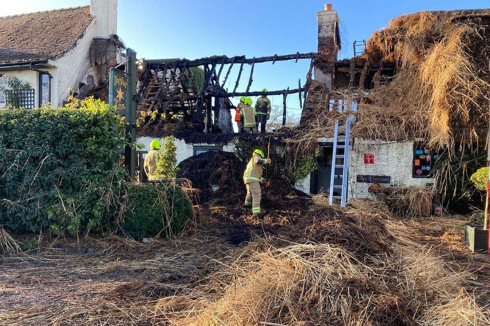 Damaged thatched roof and gutted building