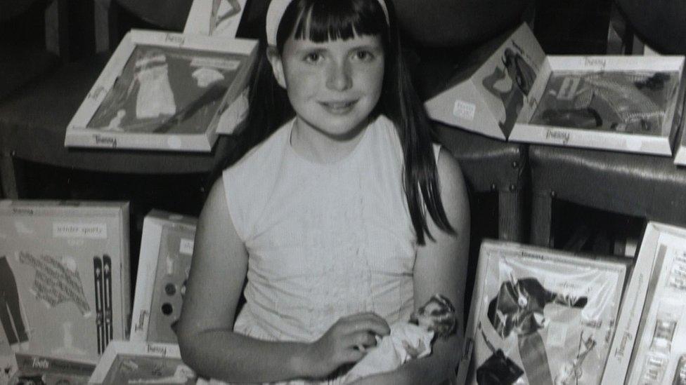 A little girl with some dolls