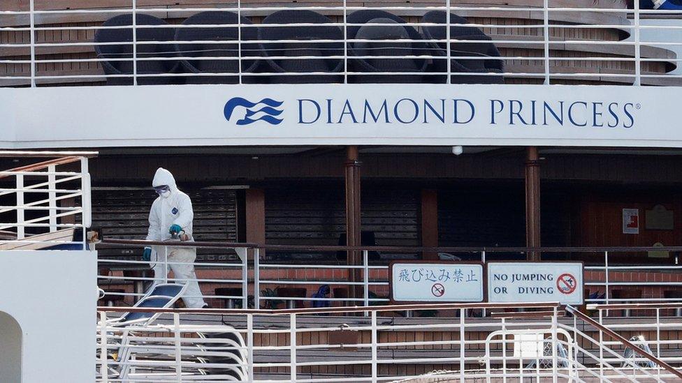 A worker in protective gear is seen on the cruise ship Diamond Princess seen at Daikoku Pier Cruise Terminal in Yokohama, south of Tokyo