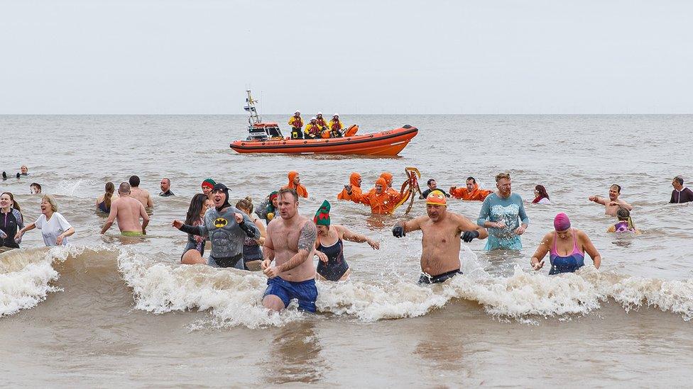 Swimmers taking to the sea at Sheringham, Norfolk, to raise money for the lifeboat service