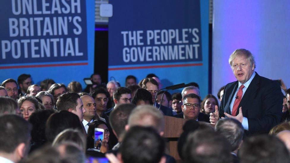 Boris Johnson at podium delivering speech at QE2 centre in central London