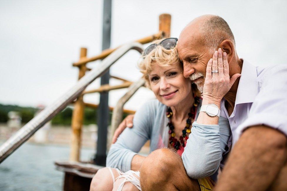 Man and woman sit on dockside