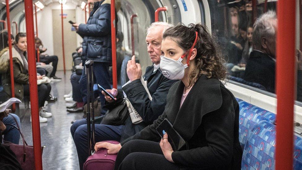 A woman in a mask on the London Underground