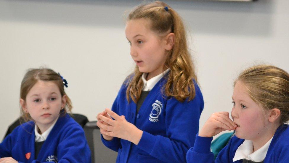 Three primary school girls in blue uniforms