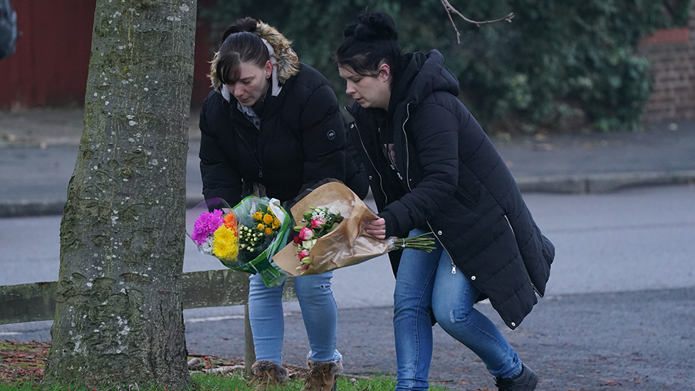 Flowers being placed at tree