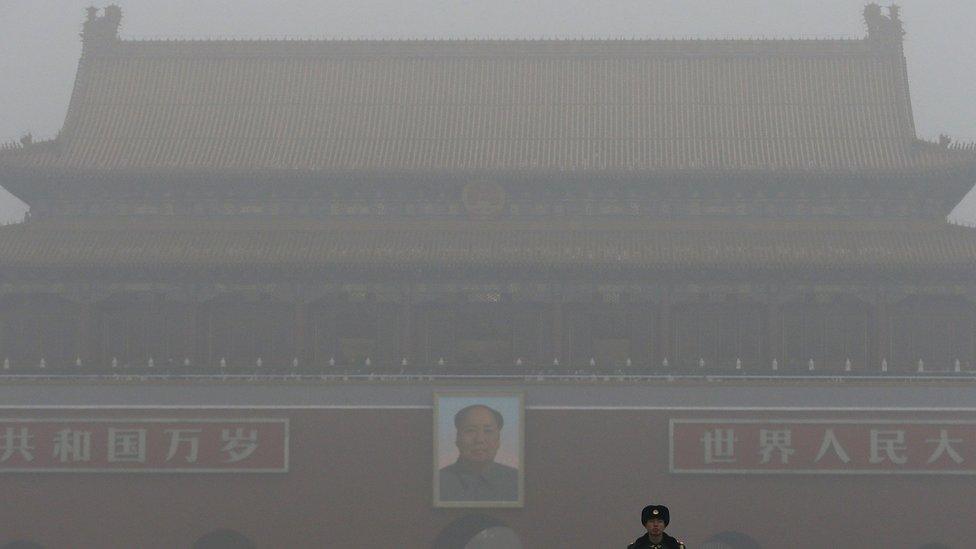 A paramilitary police officer stands guard near Tiananmen Gate shrouded with heavy pollution and fog in Beijing, China on Tuesday, Dec. 1, 2015.