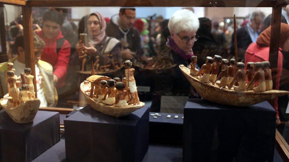 Visitors take photos of archaeological pieces at the Egyptian museum, Cairo