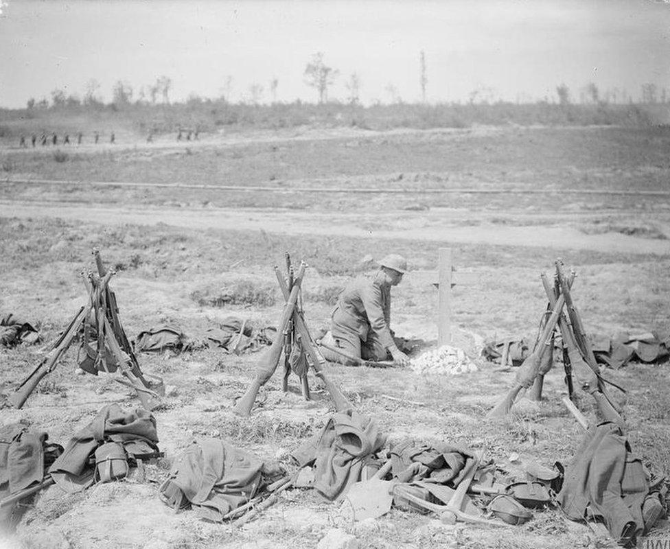 Man of a working-party attending to a war grave, near Mametz Wood. August 1916