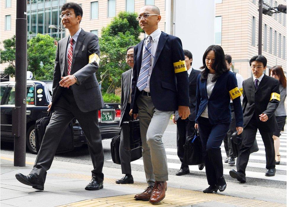 Labour Bureau officials head to Dentsu's headquarters for an on-site inspection on 14 October 2016.