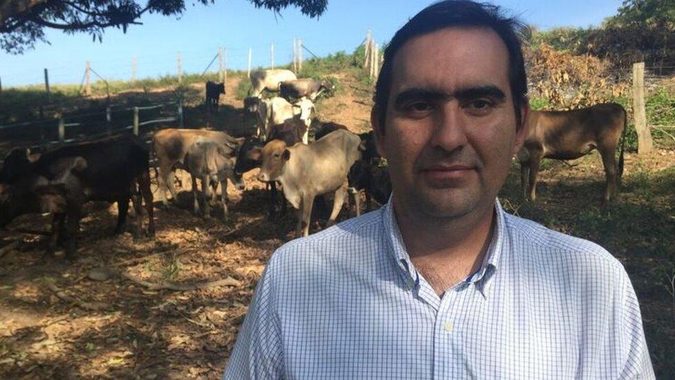 Manuel Vicente Parra stands with cattle grazing in the background