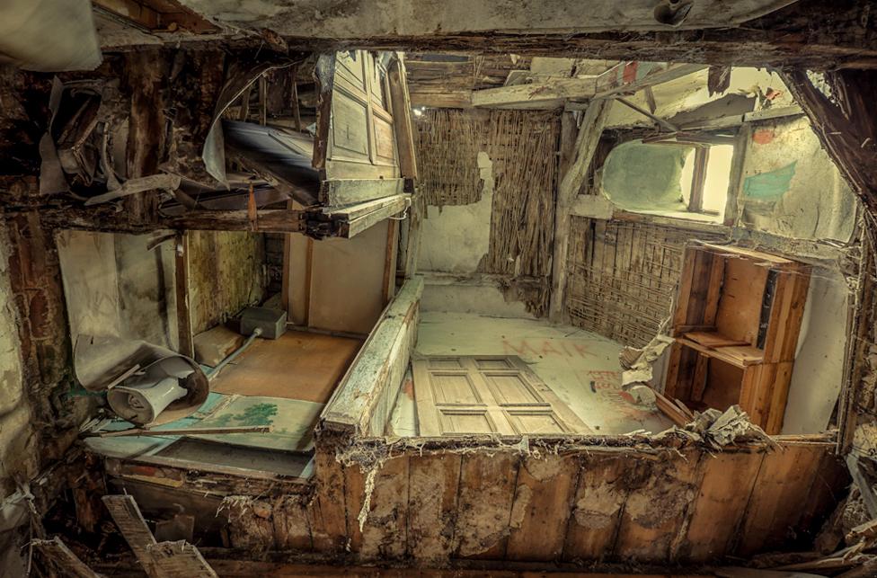 Looking up through a collapsed ceiling into a room