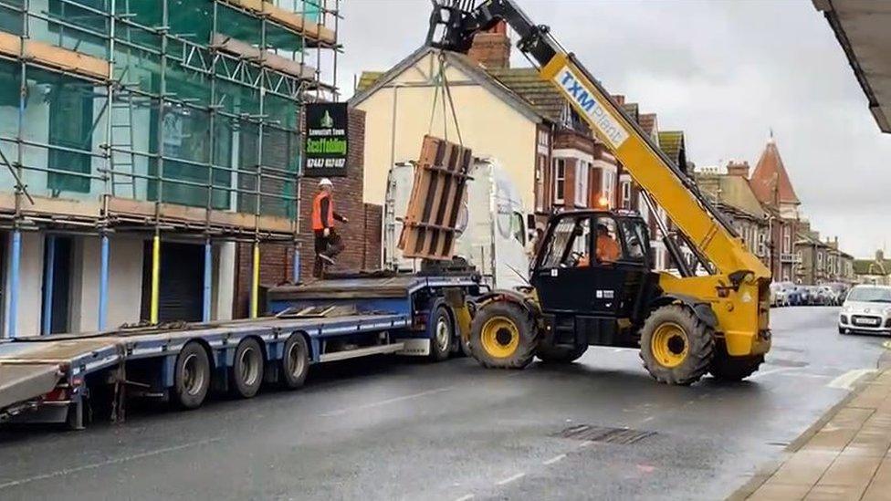 Banksy being removed from the side of an empty shop in Lowestoft