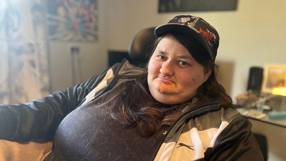 A woman in a cap sitting down in her home