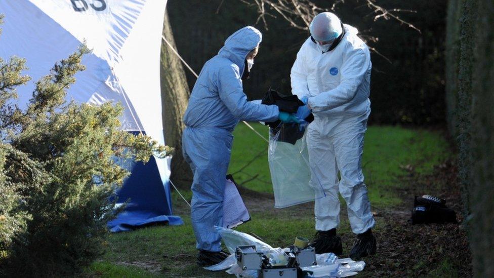 Forensic officers remove items of evidence including a green petrol can after searching an area where a man was found on fire near Kensington Palace in the early hours of Tuesday morning