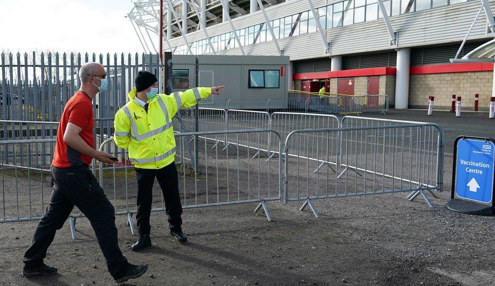 Man walks into Riverside Stadium which is a vaccine centre