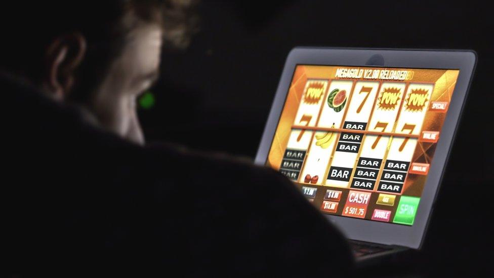 Man with glasses in front of online casino slot machine