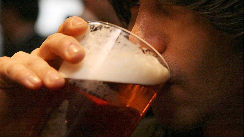 A man drinking a pint of beer