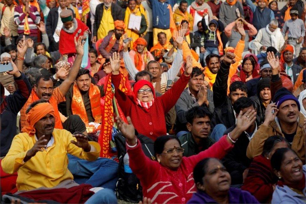 Hindu devotees chant religious slogans as they watch the inauguration of the Hindu Lord Ram temple on a big screen, in Ayodhya, India, January 22, 2024