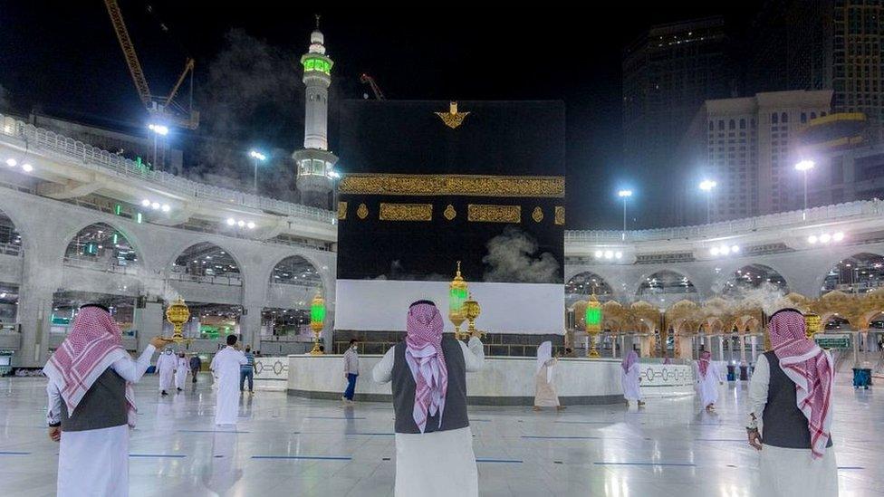 Members of the hajj staff burning incense while a few pilgrims walk round the Kaaba, at the Grand Mosque in the holy city of Mecca, on July 26, 2020