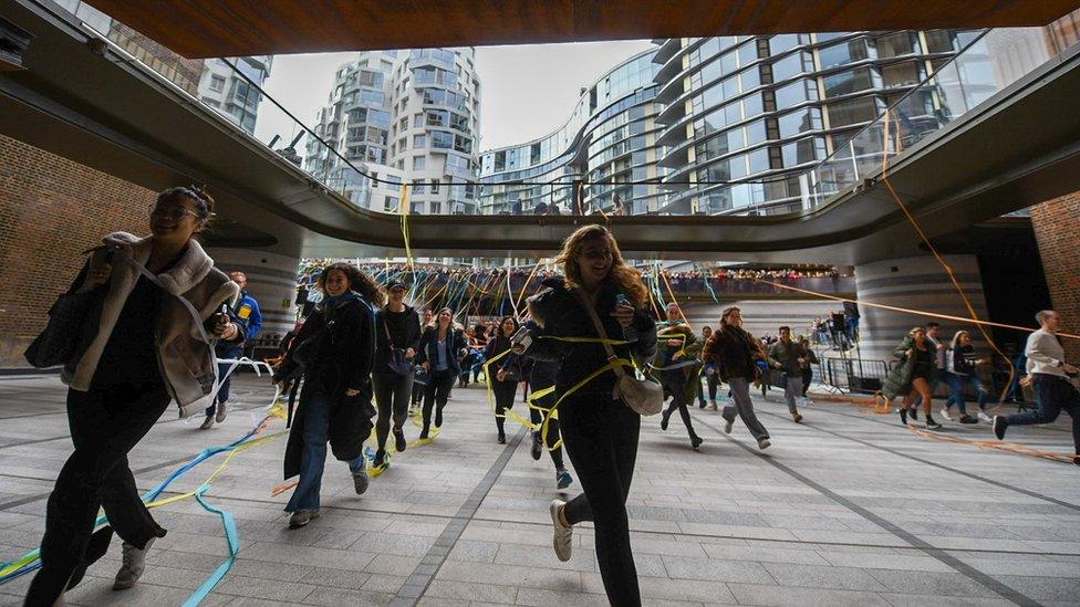 Members of the public run through streamers into the shopping centre at the power station.