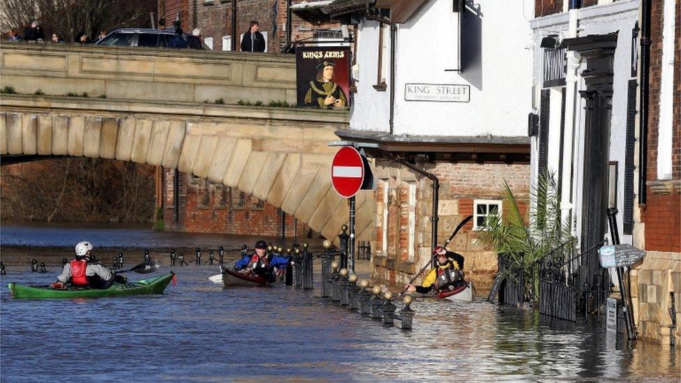 Canoeists check out buildings in flooded York on December 31, 2015