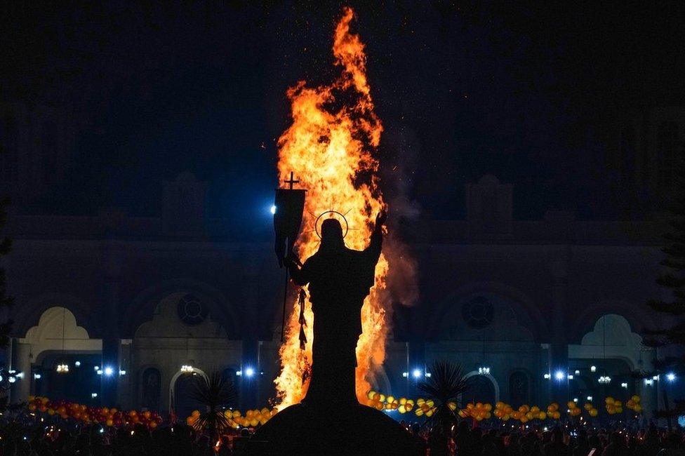 Bonfire next to statue