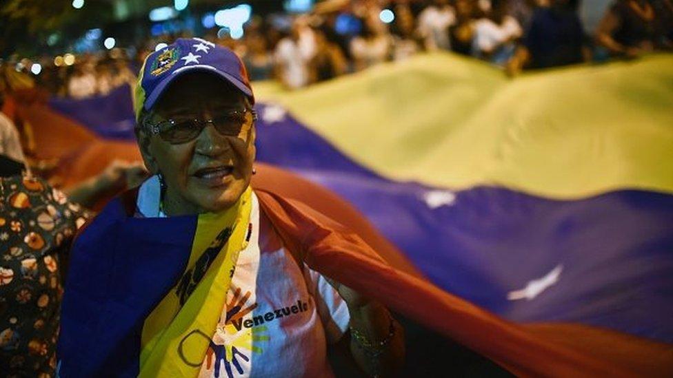 A Venezuelan opposition supporter celebrates the results of the legislative election in Caracas, on December 7, 2015