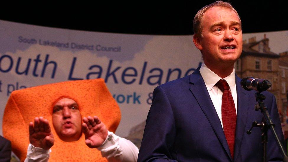 Leader of the Liberal democrats Tim Farron stands in front of Independent candidate Mr Fishfinger following the announcement of the results and that he would keep his seat at the Westmoorland and Lonsdale constituency count at Kendal Leisure Centre on June 9, 2017 in Kendal, United Kingdom.