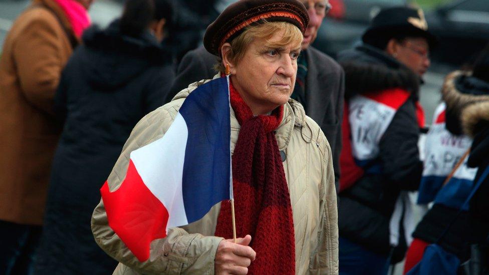 Woman holds the French flag outside Les Invalides