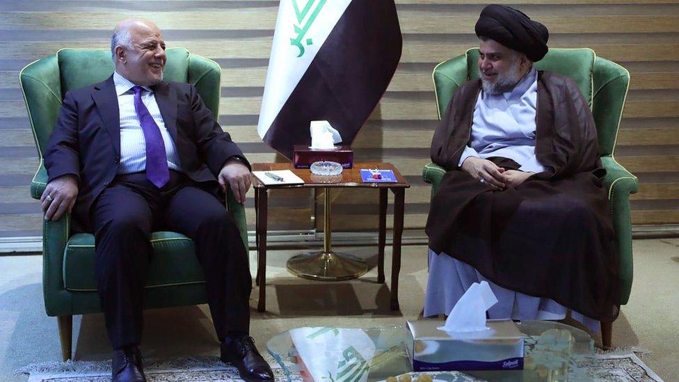 Iraqi Prime Minister Haider al-Abadi (L) talks to Moqtada Sadr (R) in Baghdad on 20 May 2018