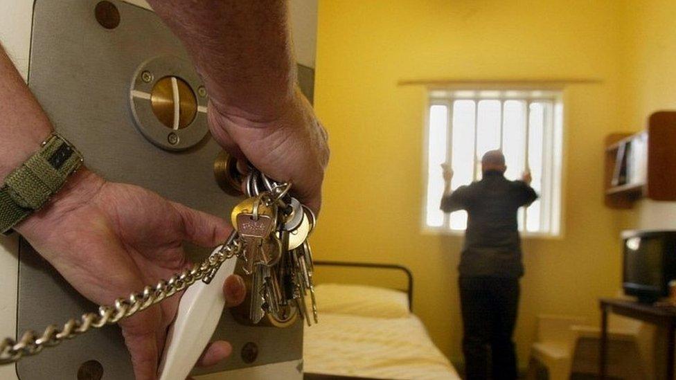 Prison officer opening a cell door