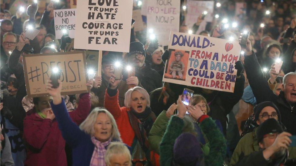 Demonstrators hold placards during a protest in Glasgow against US President Donald Trump's controversial travel ban on refugees and people from seven mainly-Muslim countries