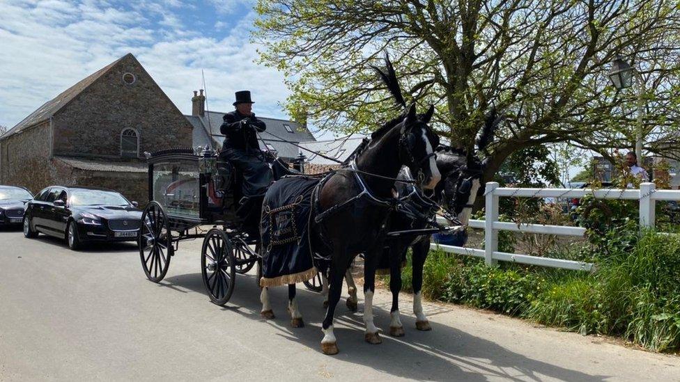 horse and carriage holding coffin