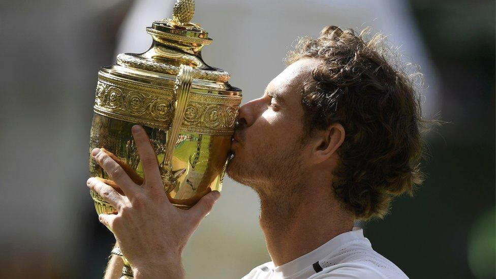 Andy Murray kissing his 2016 Wimbledon trophy.