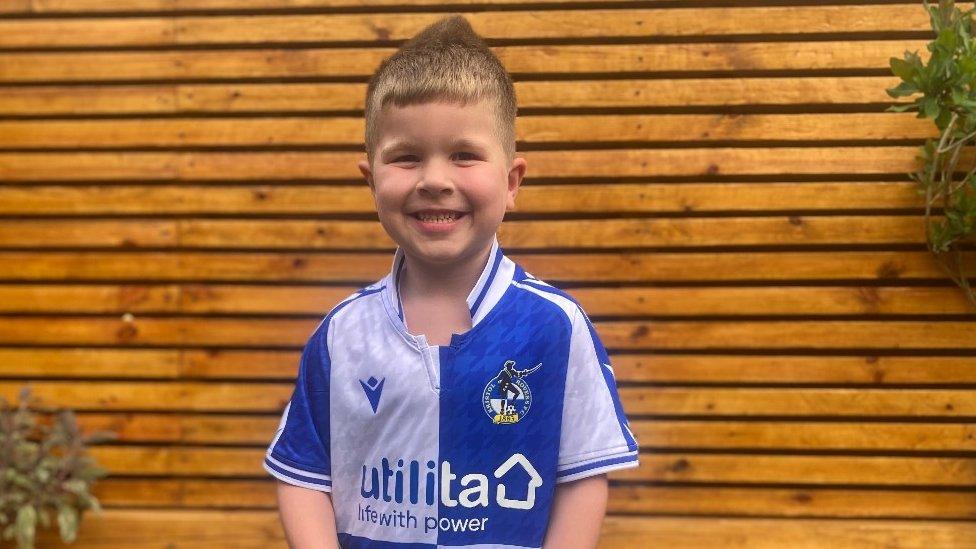 Oscar smiling at the camera wearing his Bristol Rovers shirt