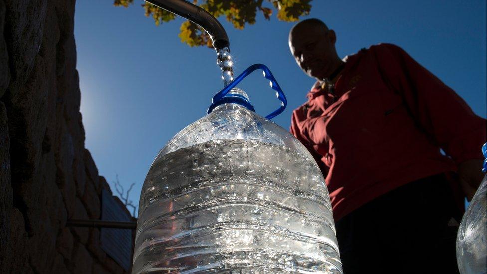 Man filling flagon from tap