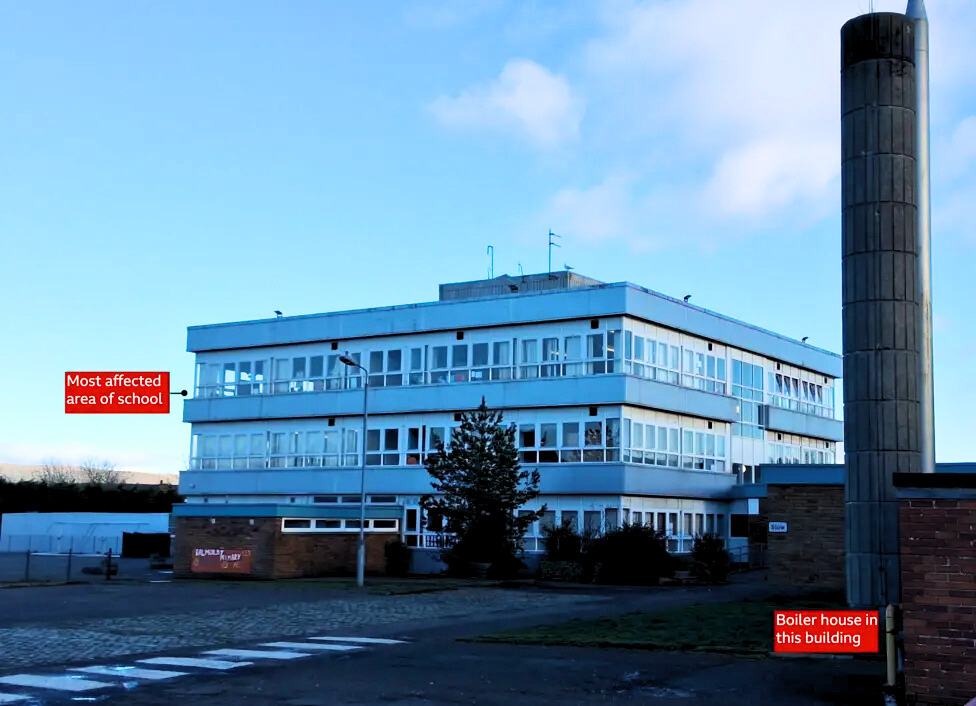 Picture of three storey building that is a primary school with a boiler house and chimney also visible