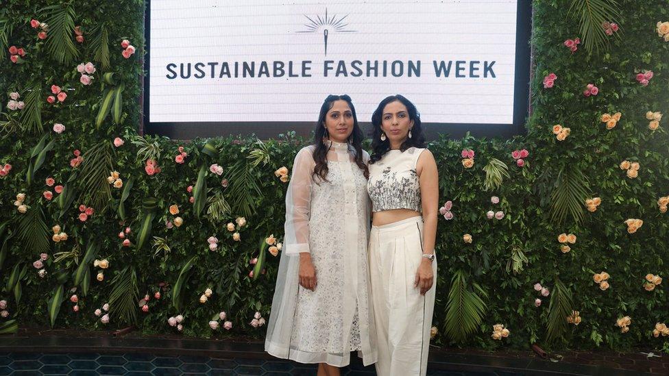 Priyanka Abhishek and Laghna Gowda standing under a Sustainable Fashion Week sign