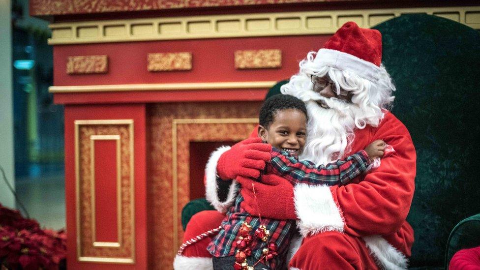 Kenny Green, playing Santa, with Christopher Pettus, at the Shops at Iverson