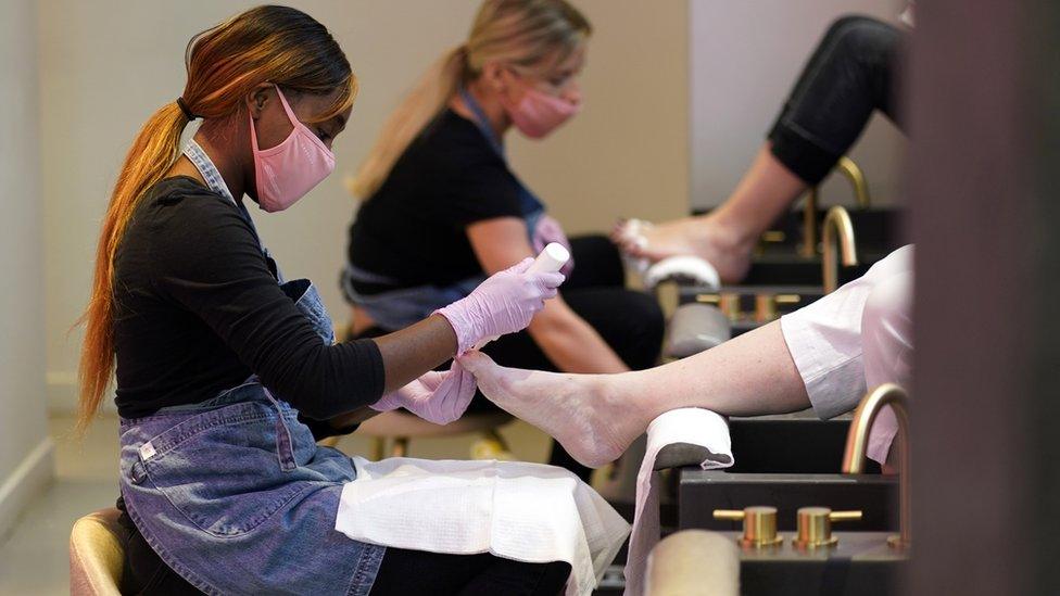 Workers tend to clients in a beauty salon