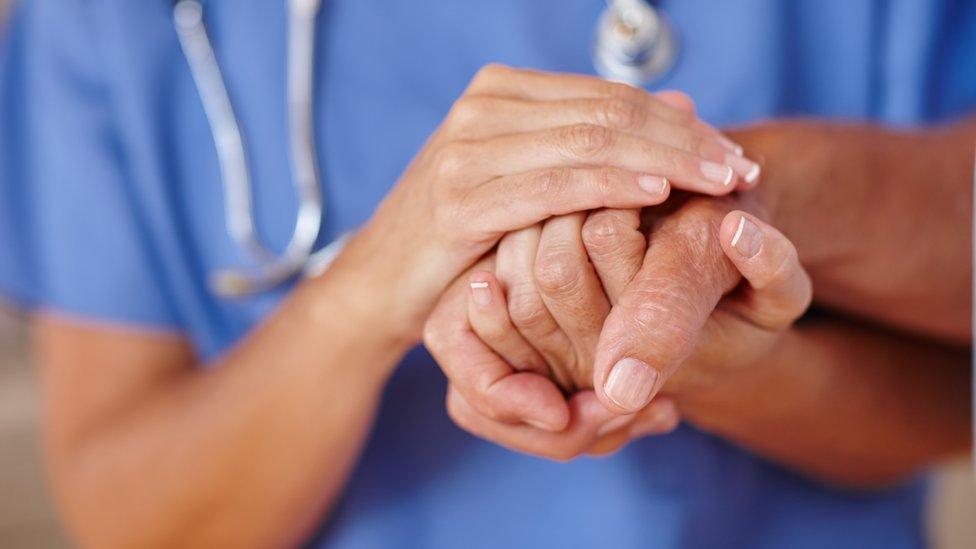 Nurse holding patient's hand