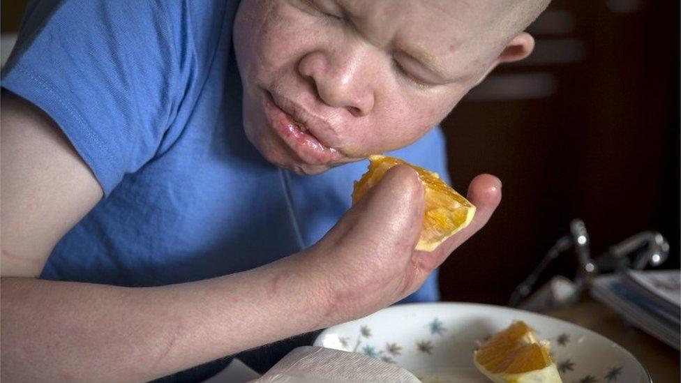 13-year-old Emmanuel Festo from Tanzania eats an orange as he does homework in the Staten Island borough of New York in the Staten Island borough of New York, September 21