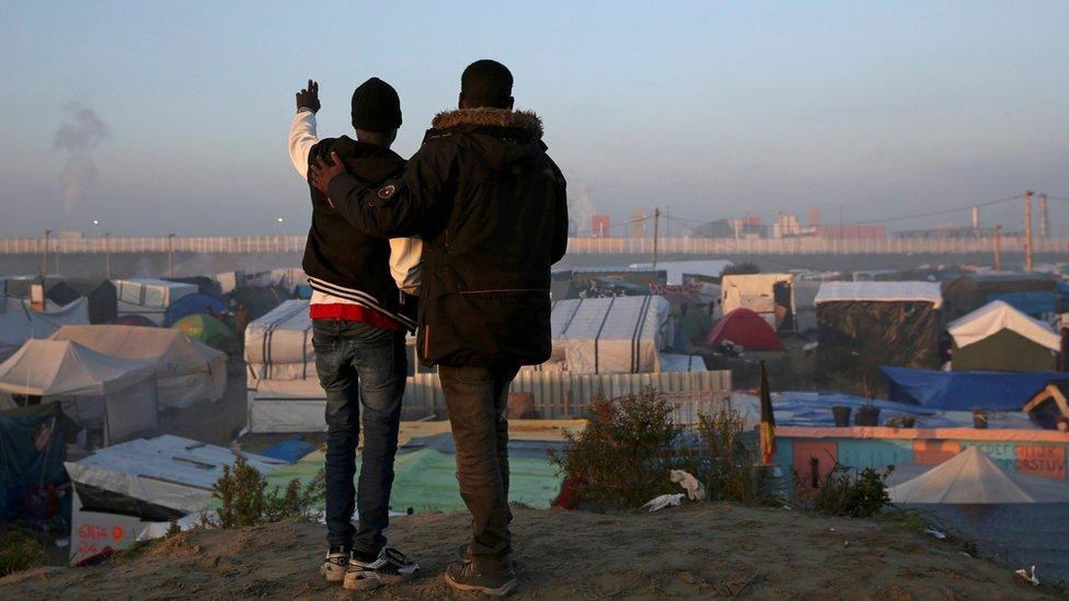 Young migrants watch the camp being demolished in 2016