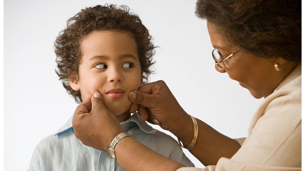 boy-having-cheeks-grabbed-by-grandparent